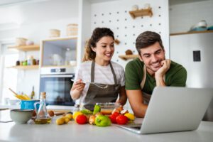 Happy young couple have fun in kitchen while preparing healthy organic food